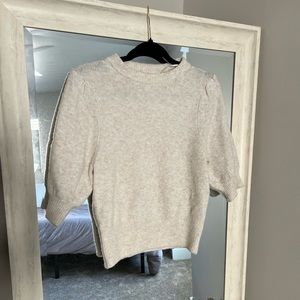 Cream sweater with puff shoulder feature.
